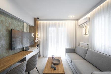 Modern one-bedroom apartment with stylish living room, fully equipped kitchen, private balcony, and contemporary design for a comfortable stay in Thessaloniki.
