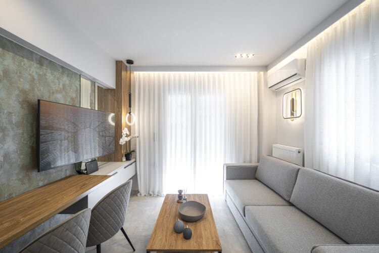 Modern one-bedroom apartment with stylish living room, fully equipped kitchen, private balcony, and contemporary design for a comfortable stay in Thessaloniki.