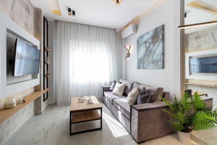Modern two-bedroom apartment with stylish living room, fully equipped kitchen, balcony, and contemporary design for a comfortable stay in Thessaloniki.