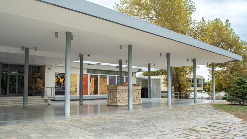 Entrance of the Archaeological Museum of Thessaloniki with modernist architecture and ancient sarcophagus on display