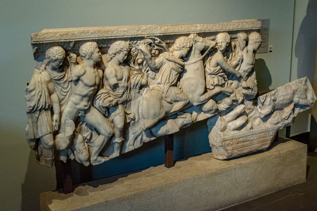 Marble relief depicting battle scene with horsemen and warriors at the Archaeological Museum of Thessaloniki